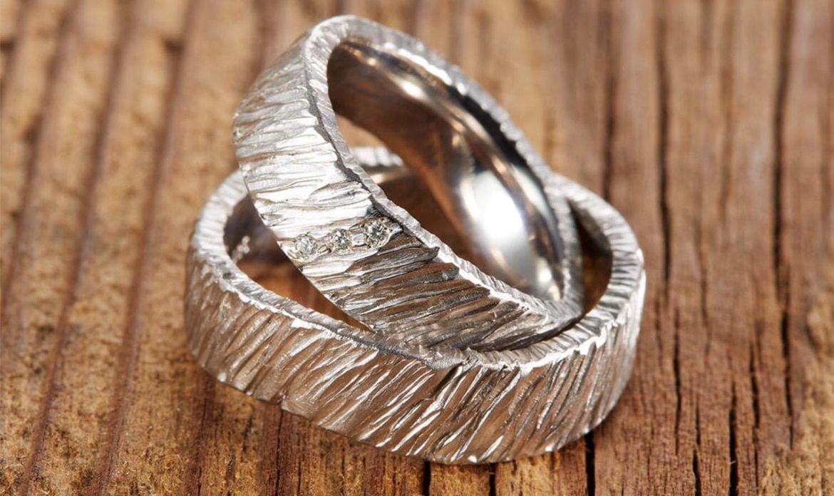 Zwei gehämmerte Eheringe aus Weißgold mit Diamanten.