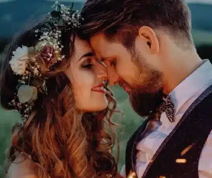 Verliebtes Brautpaar beim Hochzeitsshooting mit floraler Brautfrisur