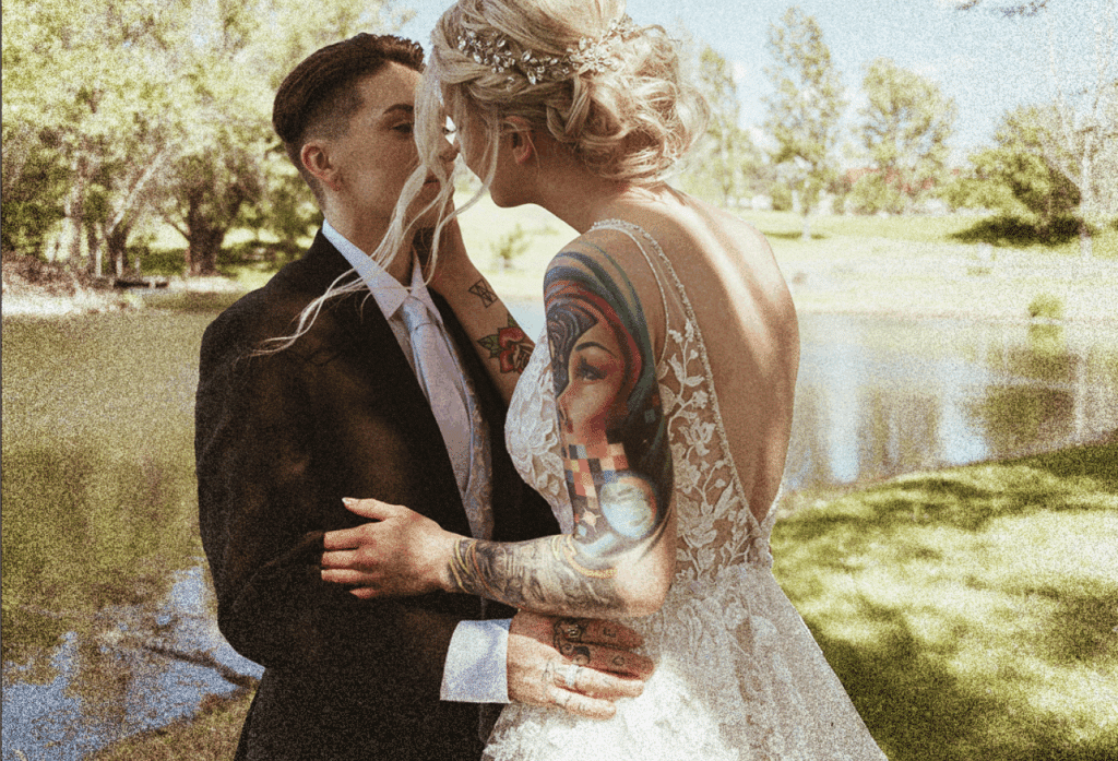 LGBTQ Hochzeitspaar mit Regenbogen-Details und individuellen Eheringen aus Gold